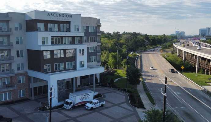 Fire Reconstruction Inc service vehicles in front of a multifamily house