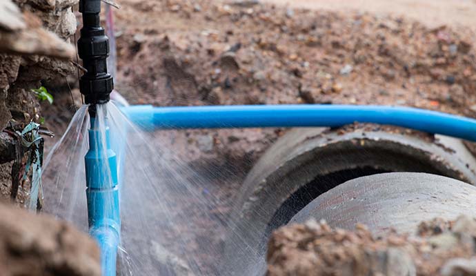 Ruptured underground main water line in trench